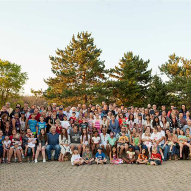 Many families gathered for a picture outdoors